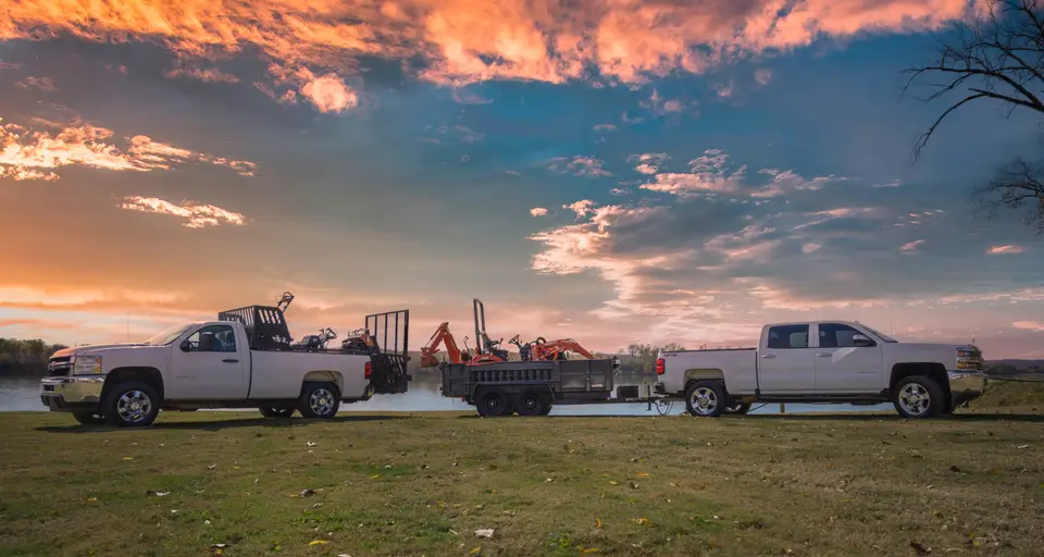 Andrew's Lawn Maintenance trucks and equipment at sunset