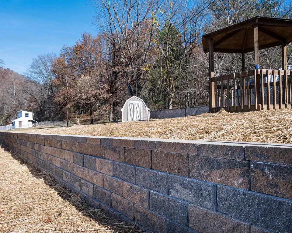 Block retaining wall below a wooden gazebo